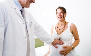 Obstetrician examining pregnant belly.